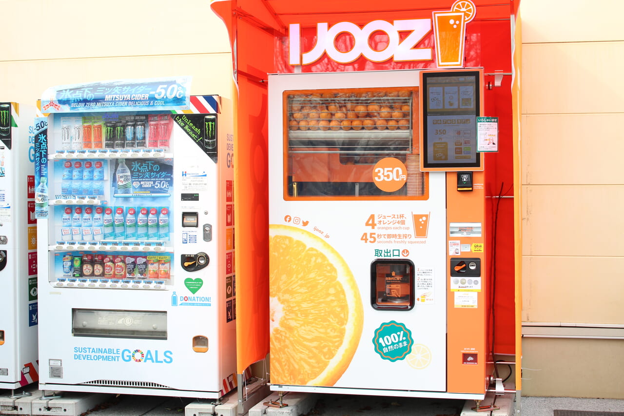 おやまゆうえんハーヴェストウォークに設置されたオレンジ生絞り自動販売機